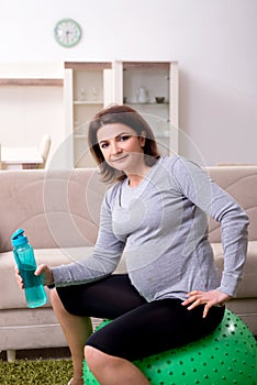 The aged pregnant woman doing exercises at home