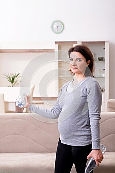 The aged pregnant woman doing exercises at home