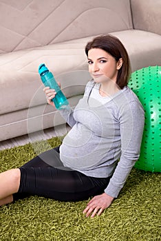 Aged pregnant woman doing exercises at home