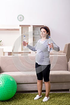 Aged pregnant woman doing exercises at home