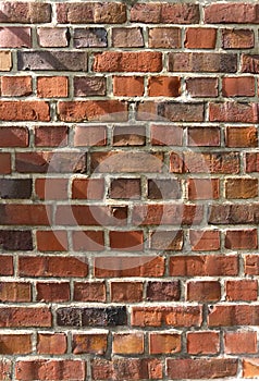 Aged red brick wall texture with sunlight