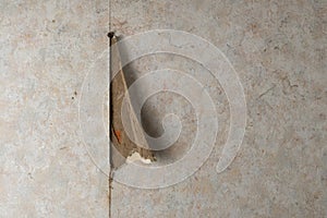 Aged room wall with torn wallpaper. Old plaster is visible from under wallpaper