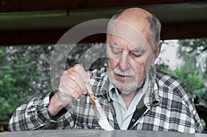 Aged senior with expressive face man painting
