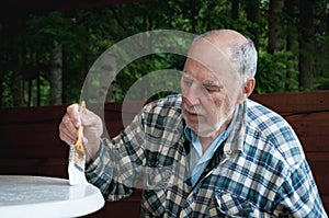Aged senior man painting with expressive face painting