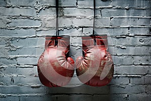 Aged Sporting Gear: Photo capturing the essence of sport with boxing gloves gracefully placed on an aged wall, invoking
