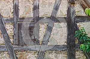 Aged, stone wall with a window, framed by wooden beams in Rothenburg ob der Tauber