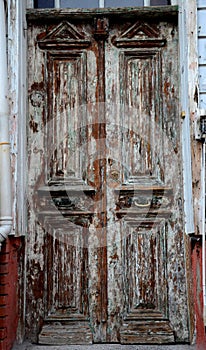 Aged weathered wooden entrance doors with peeling paint