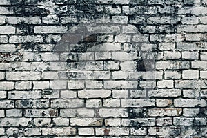 Aged white painted brick wall texture. Old textured grunge wall surface background pattern of masonry. Cracks and black stains.