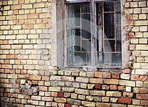 Aged window with bars in brick wall