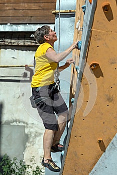 Aged Woman Climbing Wall