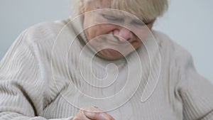 Aged woman eating untasty porridge with disgust and throwing spoon, nursing home