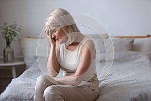 Aged woman feels unwell suffers from barometric pressure headache photo