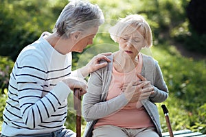 Aged woman having pain in the chest outdoors