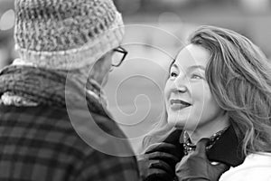 Aged woman looks into man face. Happy lady listen story. woman talks to man in glasses and in hat. Happy couple meet. closeup face