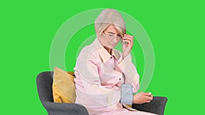 Aged woman measuring blood pressure Reaction on a high or low pressure on a Green Screen, Chroma Key.