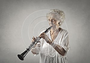 Aged woman playing a clarinet