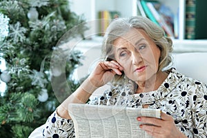 Aged woman reading newspaper