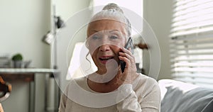 Aged woman receiving medical consultation talking by smartphone