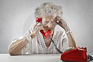 Aged woman talking at a vintage phone