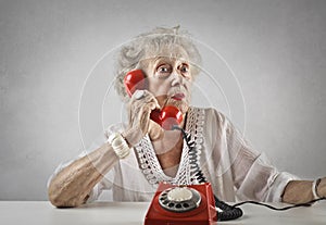 Aged woman talking at a vintage phone