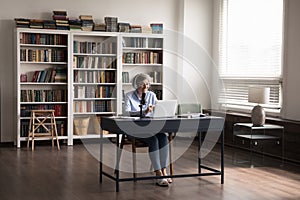 Aged woman talks into microphone use laptop lead online stream