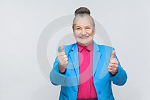 Aged woman toothy smiling and showing like sign