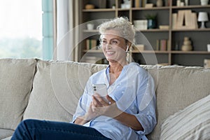 Aged woman wear wireless earphones listens messages or music