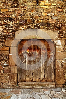 Aged wood door in medieval masonry Pyrenees