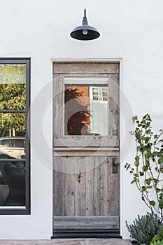 Aged wooden door to a white home