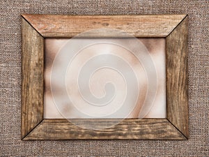 Aged wooden frame on hessian