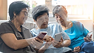 Ageing society concept with Asian elderly senior adult women sisters using mobile digital smart phone application technology