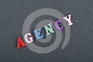 AGENCY word on black board background composed from colorful abc alphabet block wooden letters, copy space for ad text. Learning