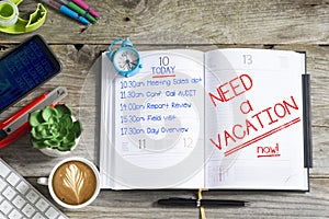 Agenda of overloaded employee or businessman with message â€œneed a vacation nowâ€