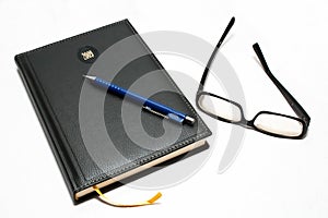 Agenda with pen and glasses