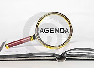 Agenda word. Concept of plans and appointments, to-do list through magnifying glass