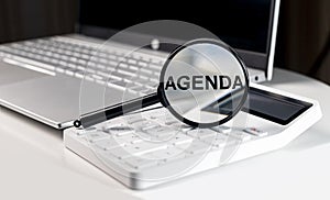 Agenda word through magnifying glass. Business concept