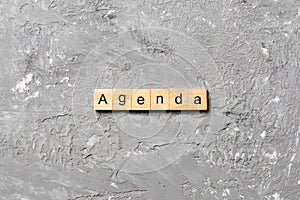 AGENDA word written on wood block. AGENDA text on cement table for your desing, concept