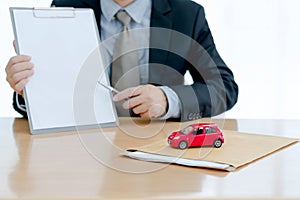 A Agent show a contract to customer signing contract car for sales rental loan and insurance concept