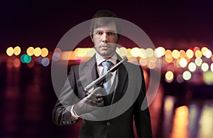 Agent or spy with gun at night. Crime concept