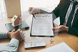 Agents are using pens pointing to insurance contracts and are being explained to customers at the office