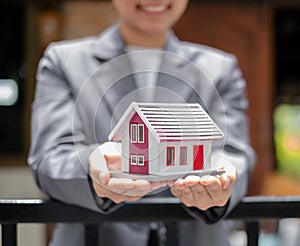 Agents working in real estate investing Agents` hands hold homes to protect the safety of customers, homebuyers, and new owners. photo