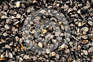Aggregate of coarse dark grey stones creating a gravel / grit pattern