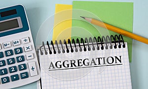 AGGREGATION - word in a white notebook on the background of a calculator, pencil, colored pieces of paper