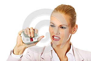 Aggresive business woman crushing small house