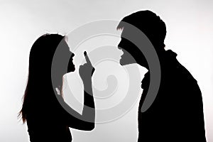 Aggression and abuse concept - man and woman expressing domestic violence in studio silhouette isolated on white