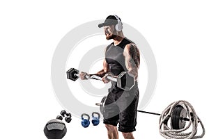 Aggressive bearded strong muscular Man in sportswear and headphones workout with barbell on white isolate