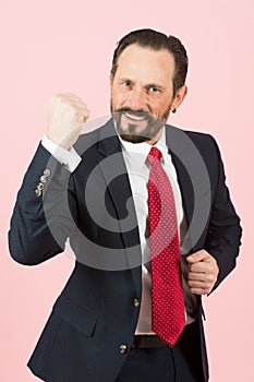 Aggressive businessman with beard wearing a blue suit and red tie fighting with angry expression. Angry man face emotion