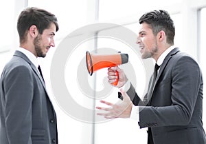 aggressive businessman with megaphone screaming on his coworker, isolated on white