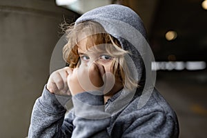 Aggressive child fight. Little kid boy fighting outside. Angry little boy showing fist. Portrait of fight kid. Bullied