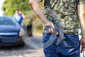 Aggressive driver with gun hidden in the back. Concept of violence in traffic. Person with gun in traffic